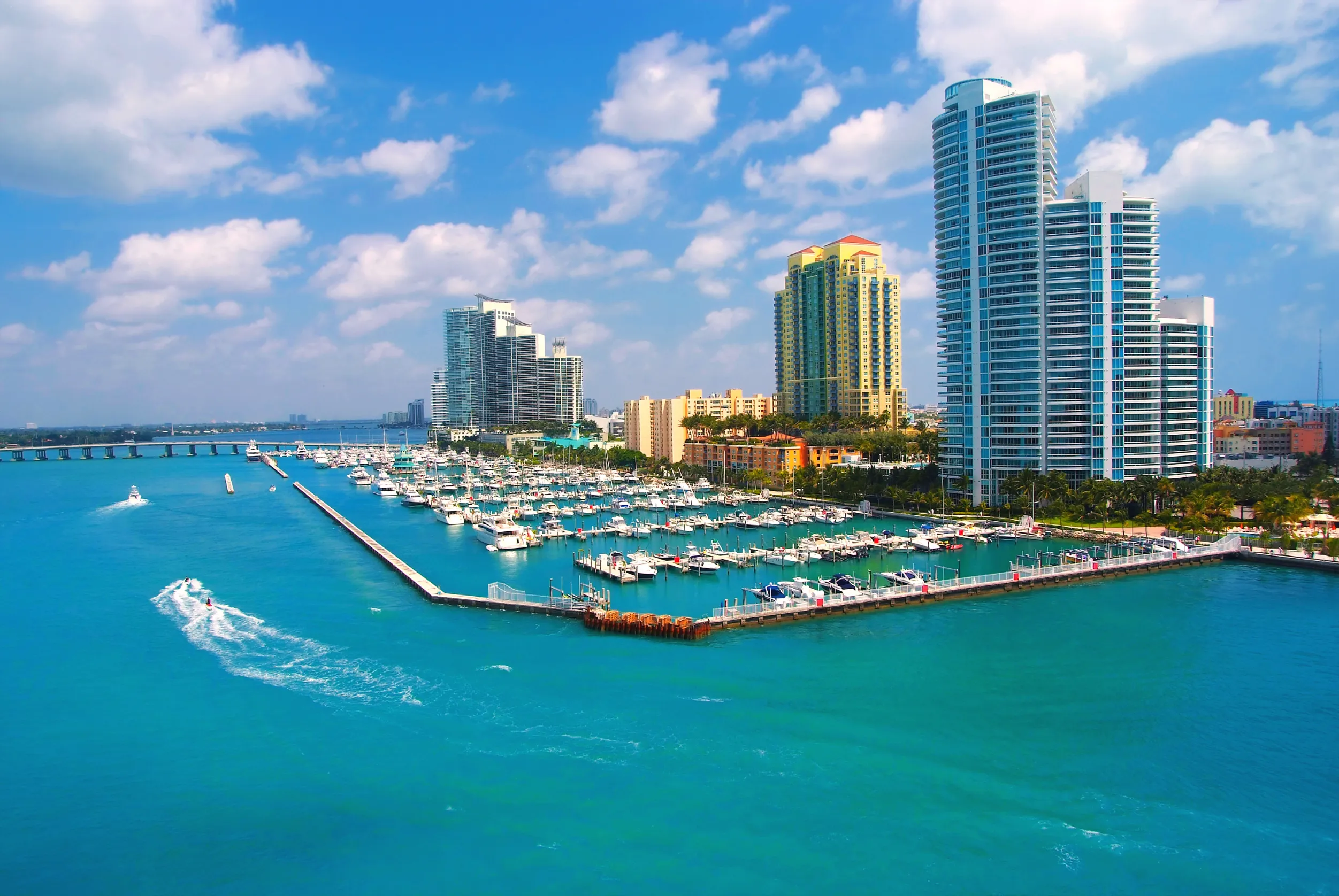 jet ski and boat sailing next to south miami beach