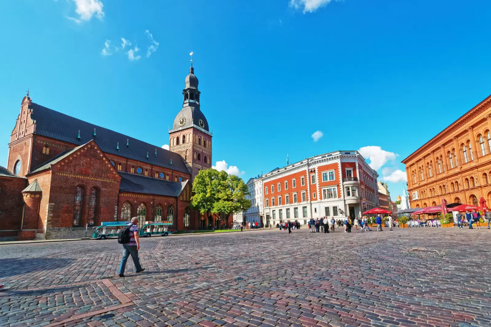 people on dome square with riga cathedral