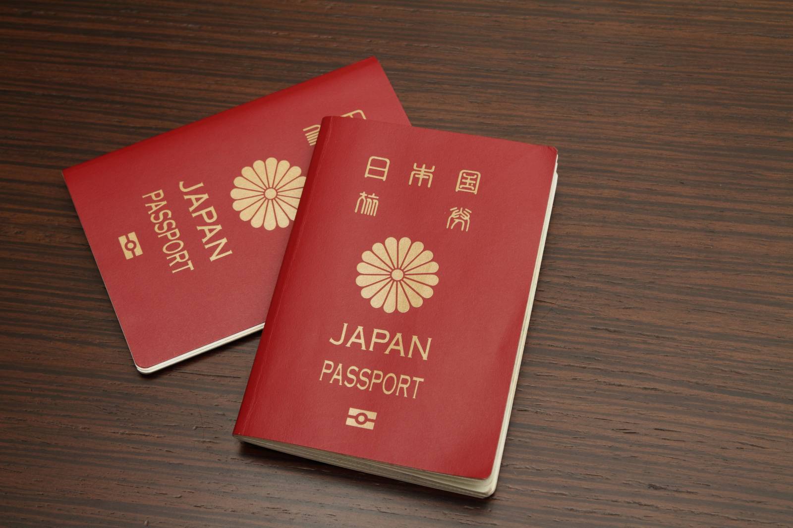 Two Japanese Passports On Wooden Surface