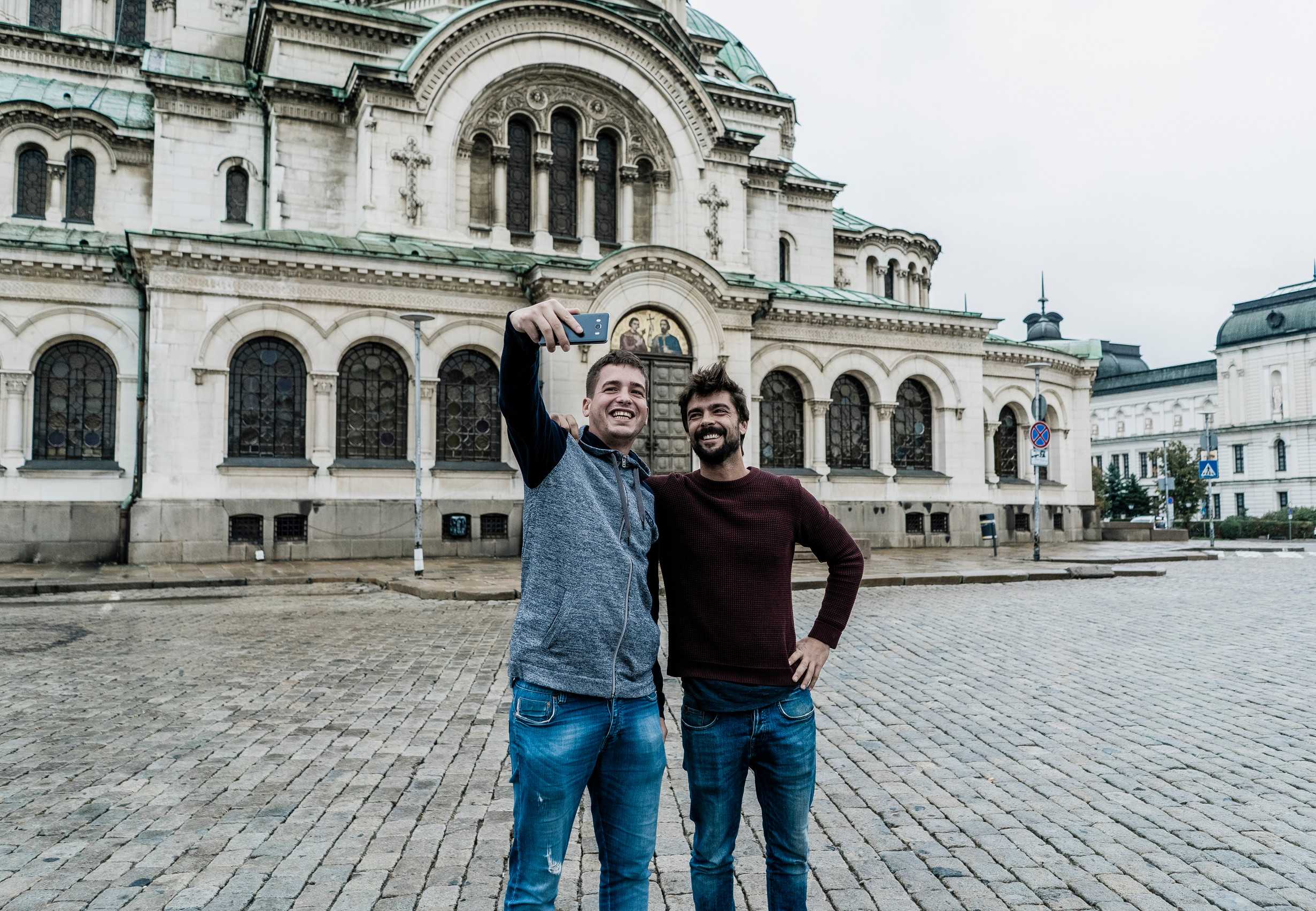 Two Young Tourists Taking Photos With Their Mobiles In Sofia Bulgaria